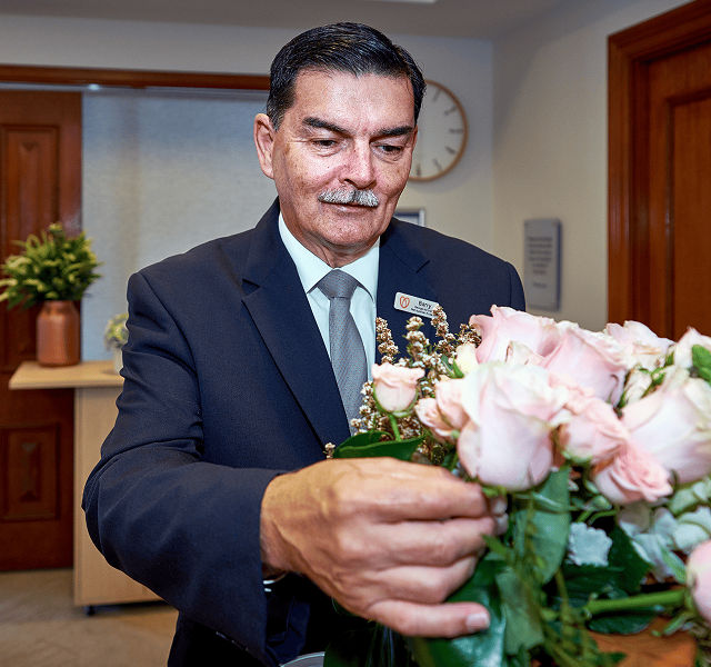 funeral director arranging flowers