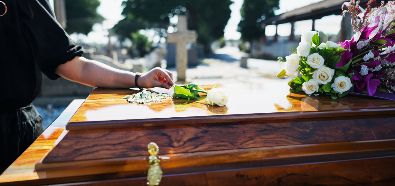 woman placing hand on coffin