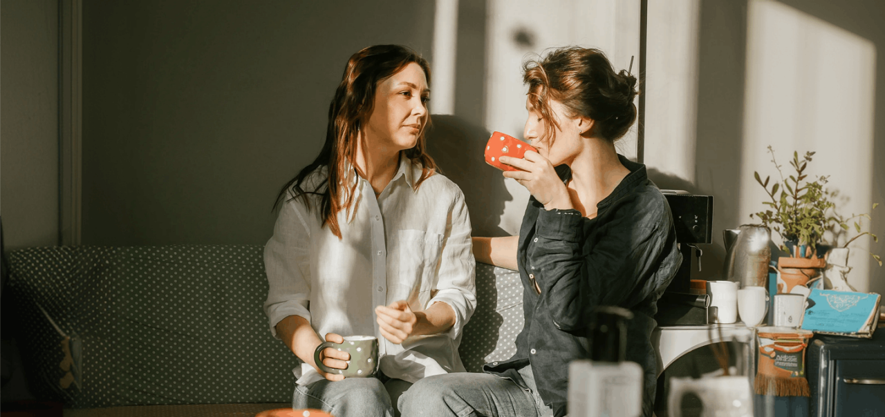 two friends chatting on lounge with coffee