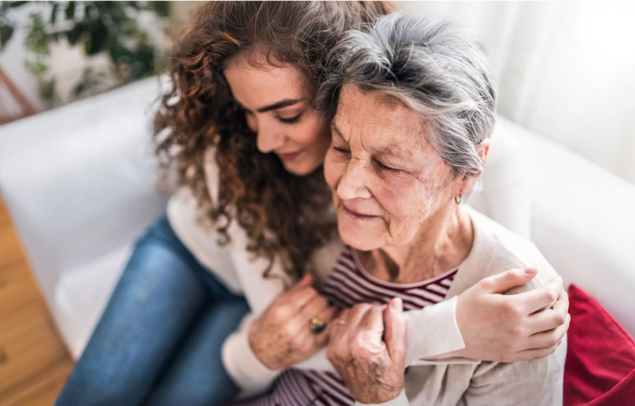 grandmother and mother hugging on lounge